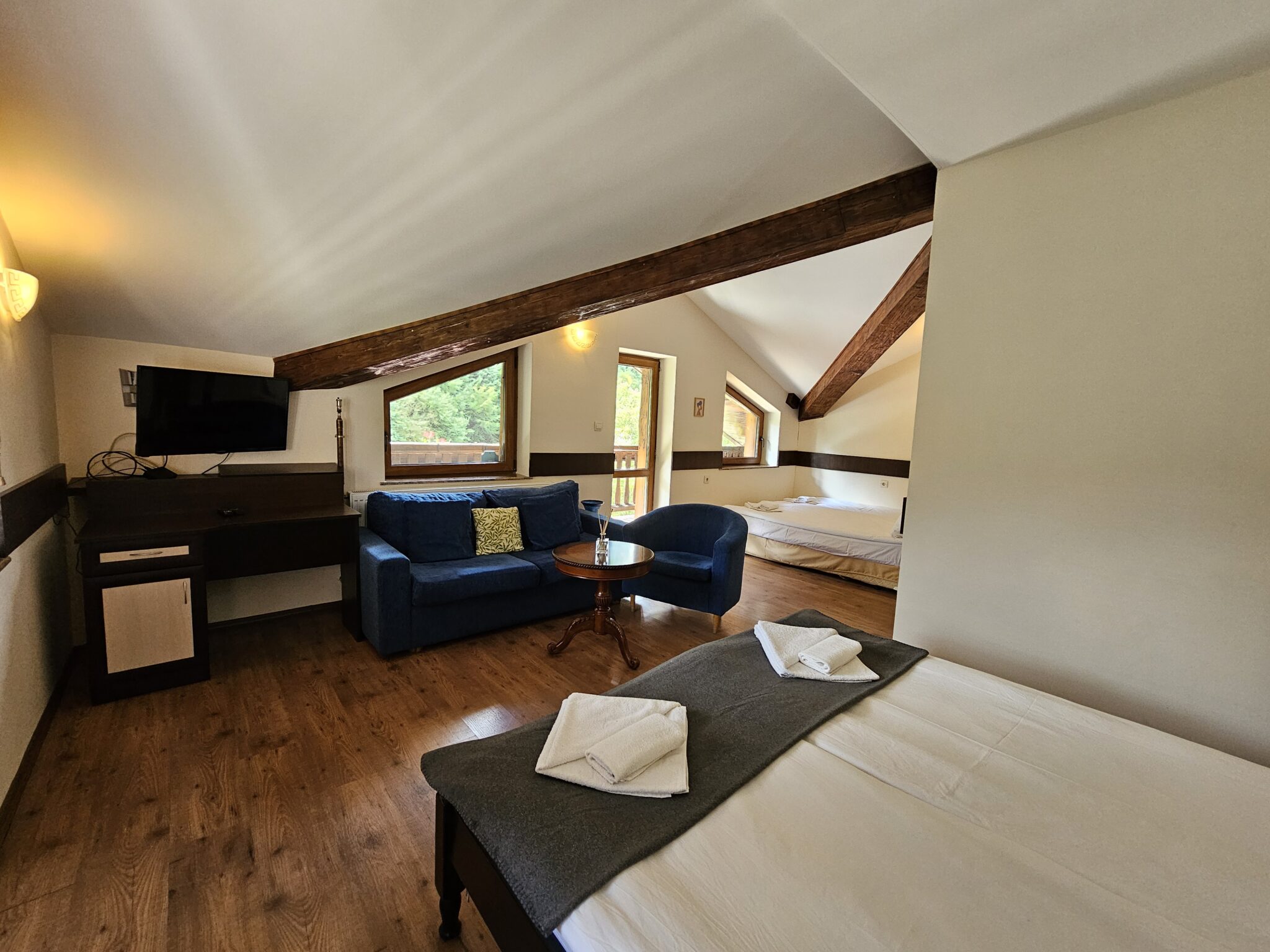 Television, blue sofa and the bed in the attic room